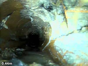 A broken drain with sections of pipe missing